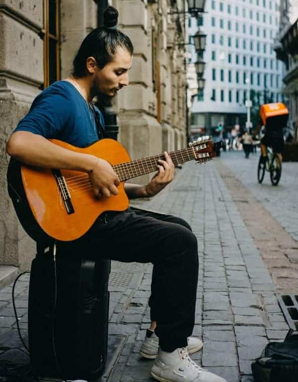 busker playing guitar with a barre chord