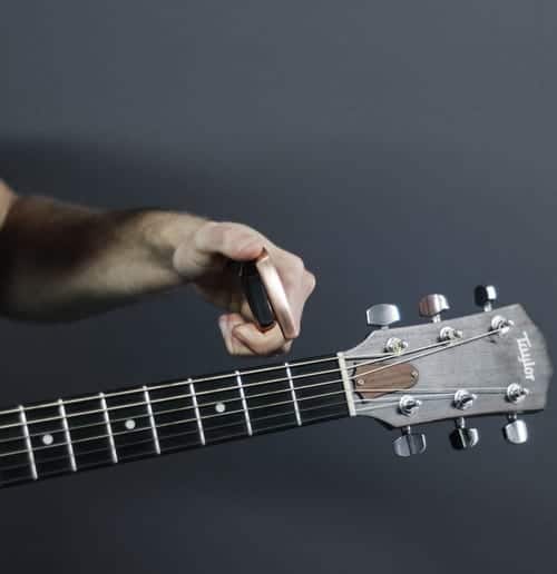 man putting a capo on a guitar
