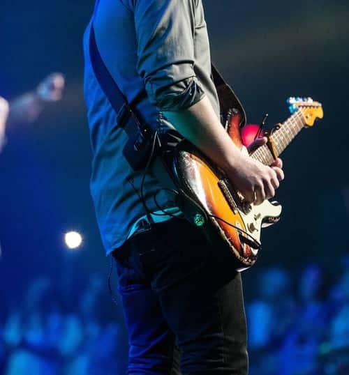 guitarist on stage with a guitar strap